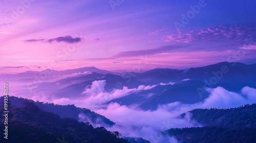 The sky is a beautiful shade of purple with clouds floating above. The mountains in the background are covered in fog, creating a serene and peaceful atmosphere