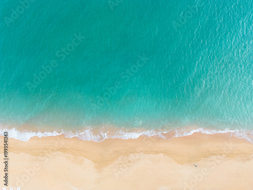 Dramatic drone overhead image of dark jagged rocks scattered along the coastline with white foaming ocean waves. Stock photo