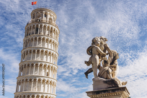 Tablou pe pânză Famous Leaning Tower of Pisa in Tuscany, Italy, with a marble cupid statue foreg