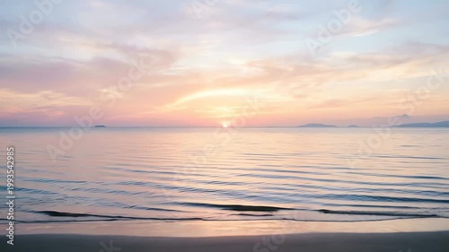 Serene sunset over calm ocean waters with gentle waves lapping at the shore