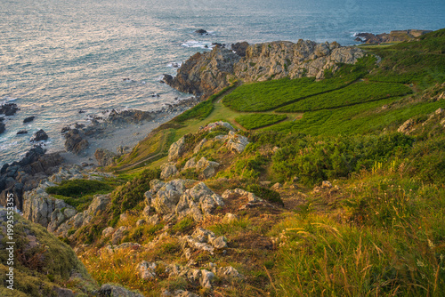 Scenic coastal landscape of Guernsey with lush greeney overlooking turquoise Atlantic ocean.