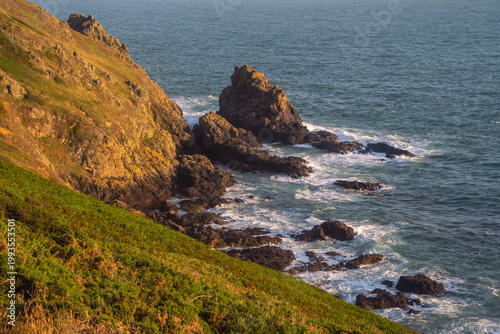 Scenic coastal landscape of Guernsey with lush greeney overlooking turquoise Atlantic ocean.