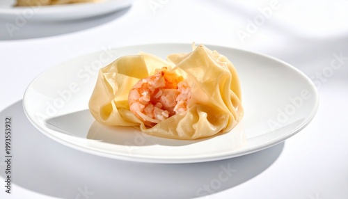 Delicate, translucent wrappers reveal succulent pink shrimp filling on a white plate, showcasing a delicious appetizer.