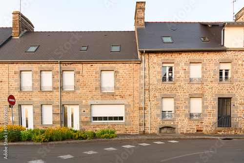Renovated stone row houses along a street at sunset in summer