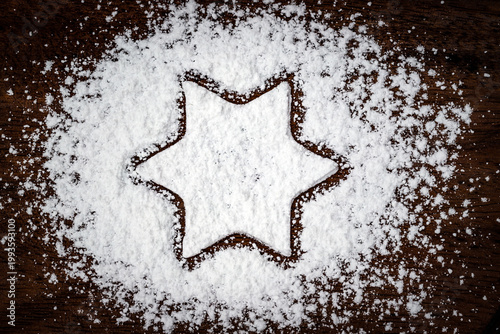 Foto Sugar powder forms a star shape on a wooden surface in a kitchen during baking p