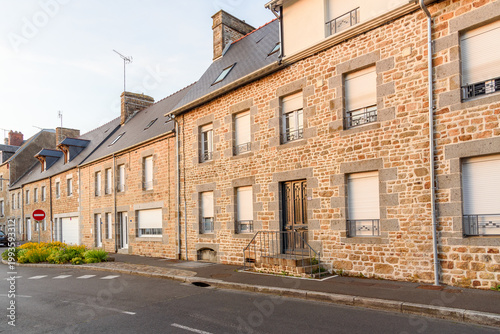 Row of renovated stone terraced houses along a street in a city centre at sunset in summer