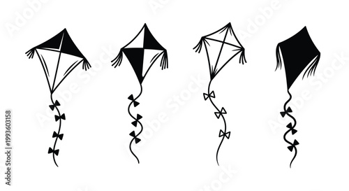 Four black and white kites with tails flying in the sky