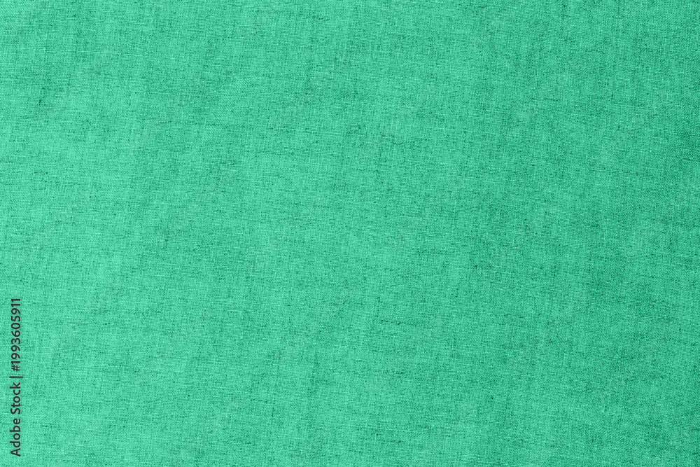 Fototapeta premium Fabric in bright green color laying flat on the surface for crafting and design purposes in a well-lit room