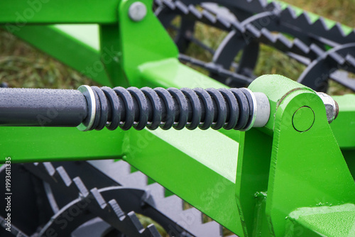 Steel black spring as part of green agricultural machine. Technology