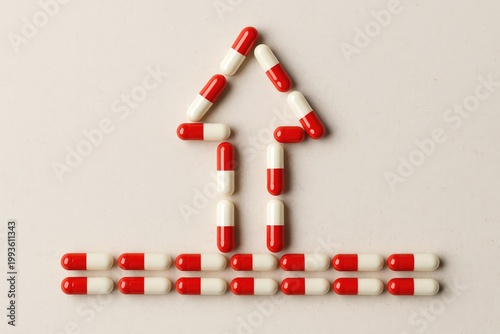 Red and white capsules arranged in an upward arrow shape on a plain surface.
