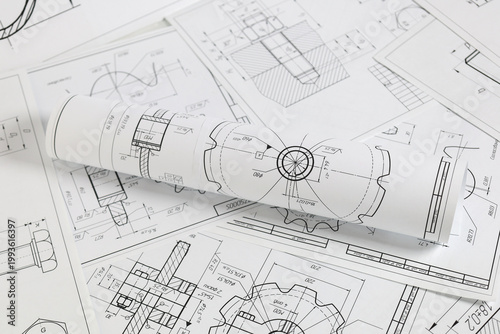 paper engineering drawings of industrial parts and mechanisms