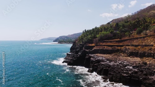 Medium height coastline shot of a beach in central America. This video has been made at El Salvador, in the coastal town of El Zonte. 