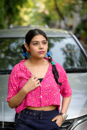 Stylish young Indian woman wearing a colourful casual outfit with vibrant accessories, posing outdoors in natural daylight