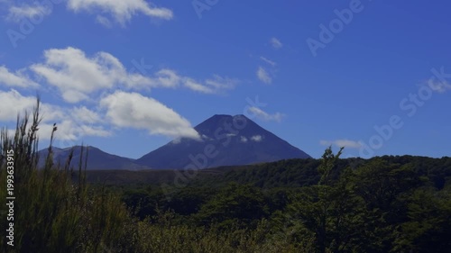 Hikers in the foreground with the majestic volcanic peaks of Tongariro National Park in the distance