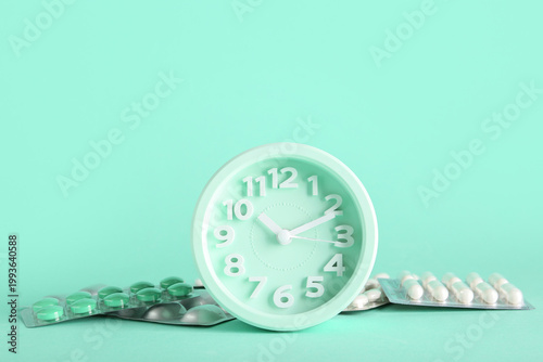 Pills and alarm clock on tu...