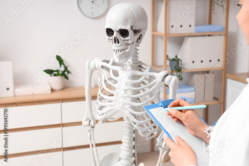 Female doctor writing on cl...