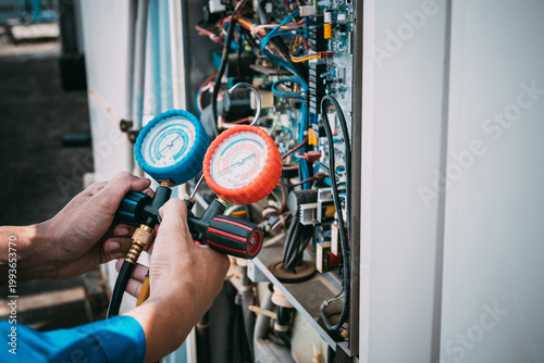 Technician is checking air conditioner refrigerant leak.