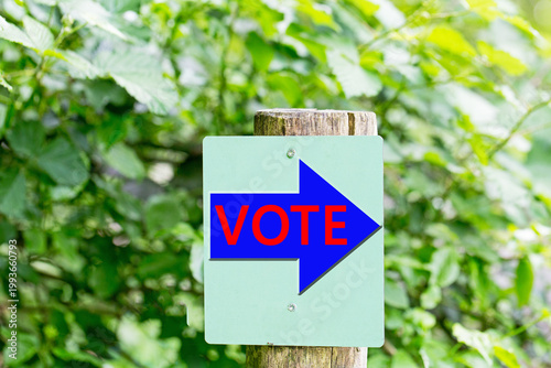 Vote sign points the way to polling location in a natural setting during election season