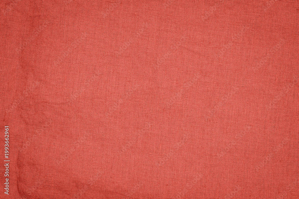 Fototapeta premium Fabric in solid orange color with a textured surface laid out flat for crafting or design projects