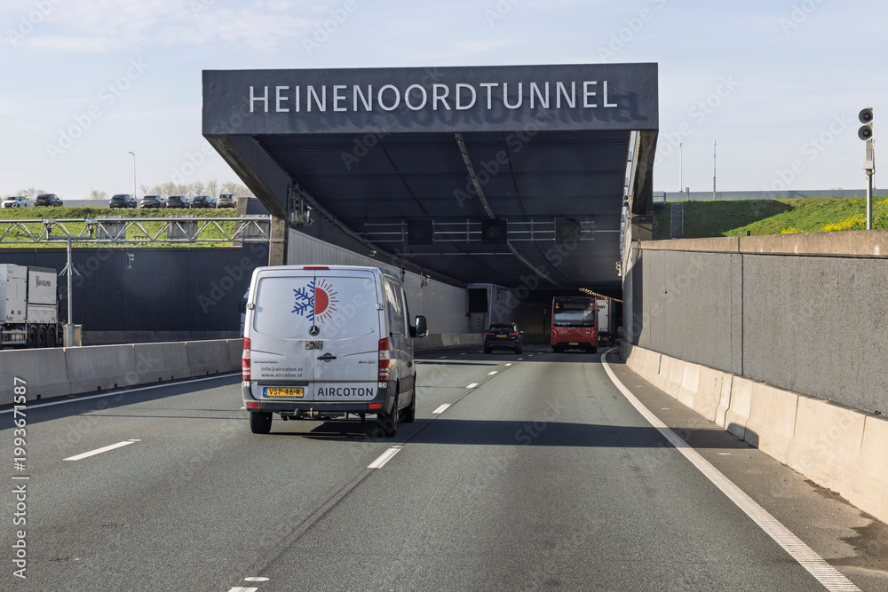 Fototapeta premium Barendrecht, Netherlands, April 15, 2026. A view of the entrance to the Heinenoordtunnel with various vehicles driving on the highway under a clear sky.