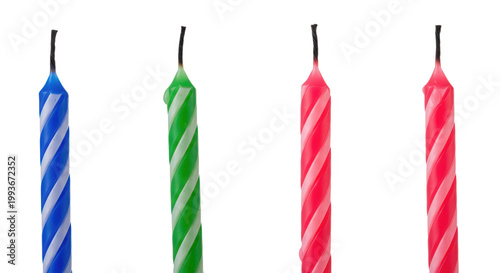 Four burnt birthday candles in blue green pink and red