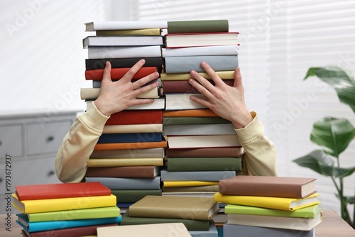 Photography Man with many books at table indoors