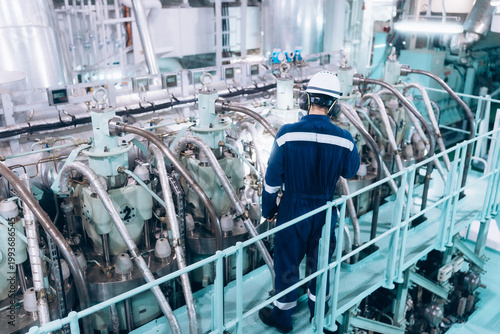 Marine engineer conducting a safety inspection of the ship's main engine.