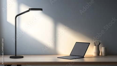 Modern workspace setup with laptop and stylish lamp on wooden desk