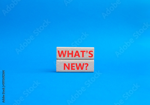 What is new symbol. Concept word What is new on wooden blocks. Beautiful blue background. Business and What is new concept. Copy space