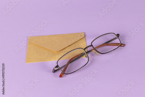 Brown Envelope and Glasses on Purple Background: Minimalist Office Theme