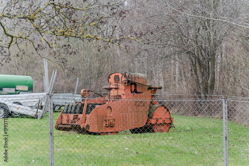 Old rusty agricultural machinery on field in natural environment.