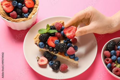 Young woman taking strawber...