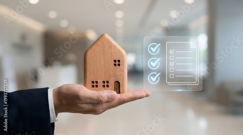A businessman holding a small wooden house model in his palm with a digital checklist interface showing completed real estate project goals.