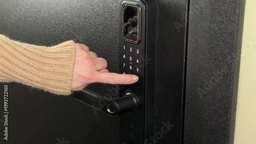 A woman opens a modern smart door lock with a digital keypad using a code.