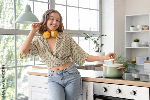 Konstfotografi Cool young woman dancing and cooking in kitchen