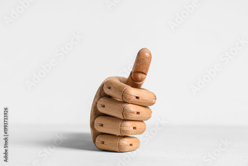 Wooden hand showing thumb-u...