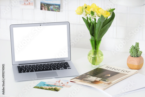 Blank laptop and vase with ...