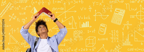 Photos A student holds a red ruler above his head while looking upwards