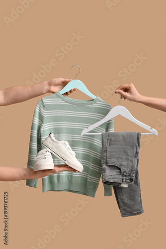 Women holding hangers with ...