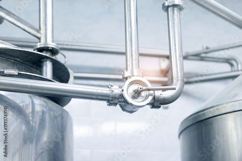 Fotografija Stainless steel piping network over processing tanks in facility milk food indus