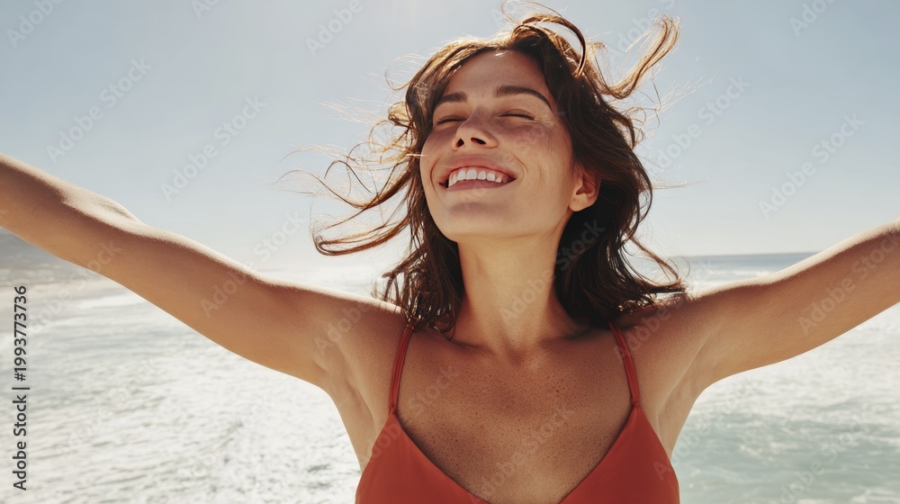 Naklejka premium Joyful woman embracing freedom by the ocean on a sunny day