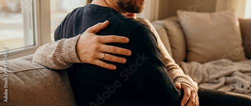 support comfort embrace tenderness cozy home trust connection warmth care a seated sofa embrace from behind shows comfort affection and emotional safety for relationship wellness and support themes