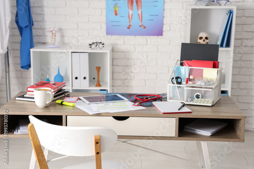 Medical student's workplace with stationery and coffee cup in clinic