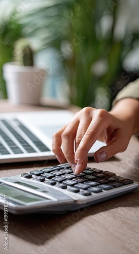 Enlarge image of woman's hand using calculator for home financial calculations, accounting with laptop on table