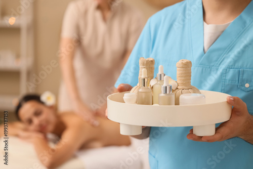 Male massage therapist with spa supplies in salon, closeup