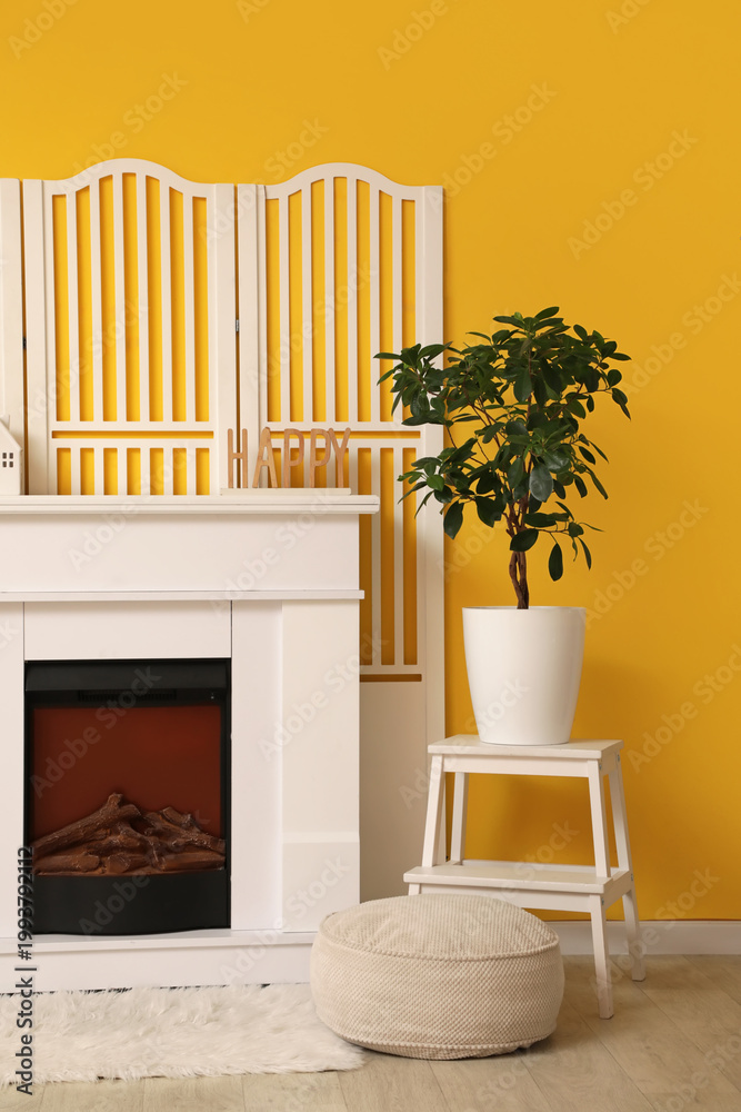 Fototapeta premium Stylish interior of living room with fireplace and white folding screen