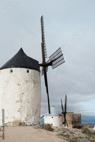 Traditional windmills with conical roofs. Castle in the background. Consuegra, Toledo
