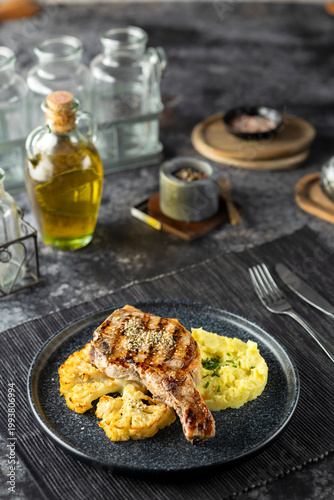 Grilled pork chop with mashed potatoes and cauliflower steak