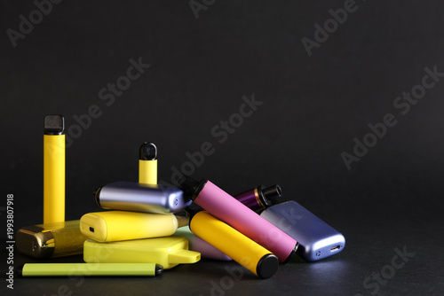Foto Colorful assortment of electronic cigarettes and vape devices on black backgroun