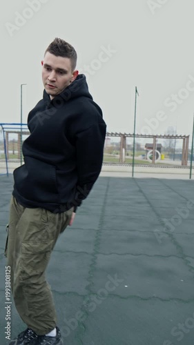 Dancing man outdoors. Creative guy in street style clothes dancing for camera outdoors. Dancer practice street dance. Vertical video. 4K, UHD